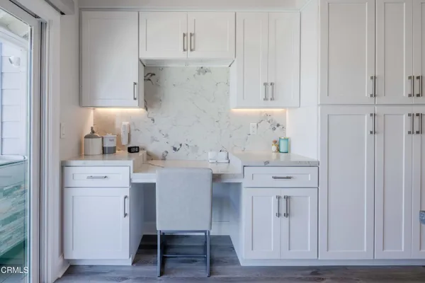 a kitchen with white cabinets and sink