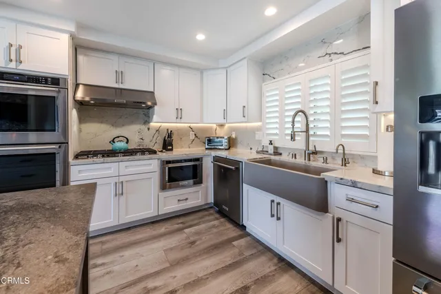 a kitchen with stainless steel appliances a stove sink microwave and cabinets