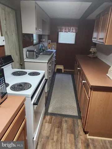 a kitchen with stainless steel appliances a stove a refrigerator a sink a counter space and cabinets