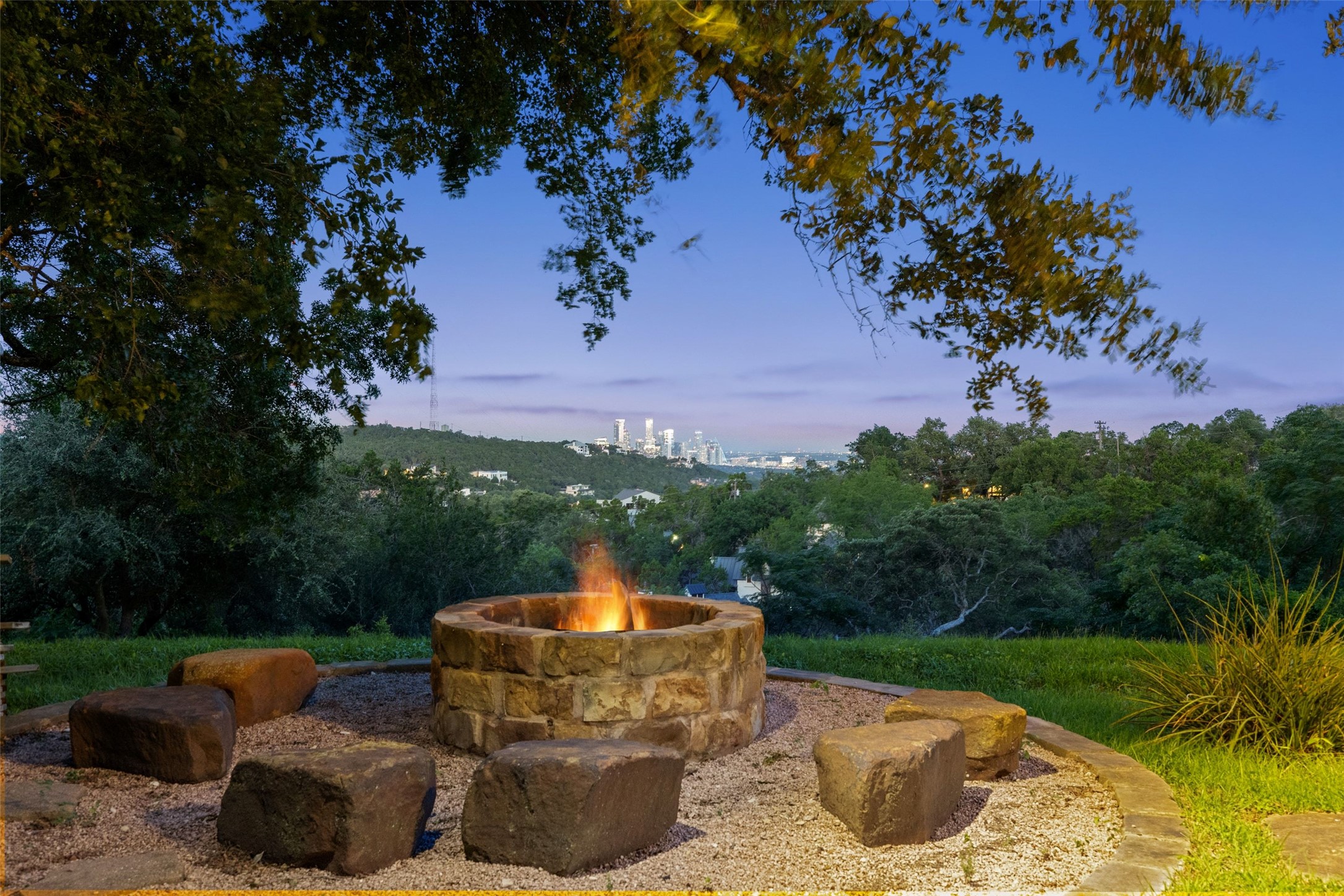 1414 The High Road Austin, TX 78746 - Photo 38 of 40 A stone-crafted fire pit provides an inviting outdoor gathering space with cityscape views.
