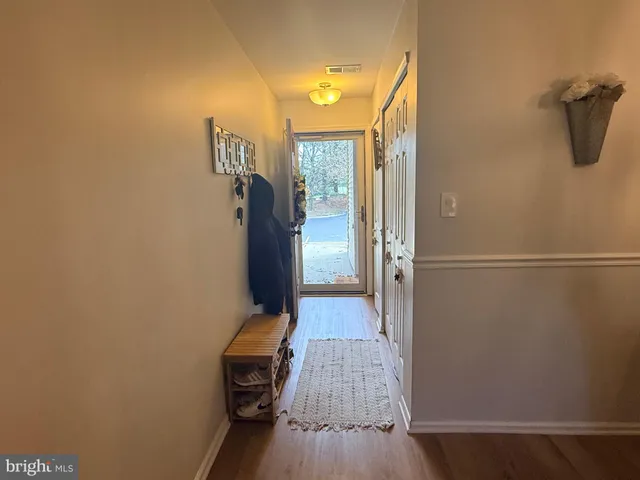 a view of a hallway with wooden floor and closet