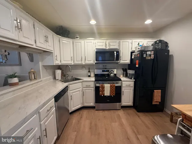 a kitchen with stainless steel appliances granite countertop a refrigerator sink and stove