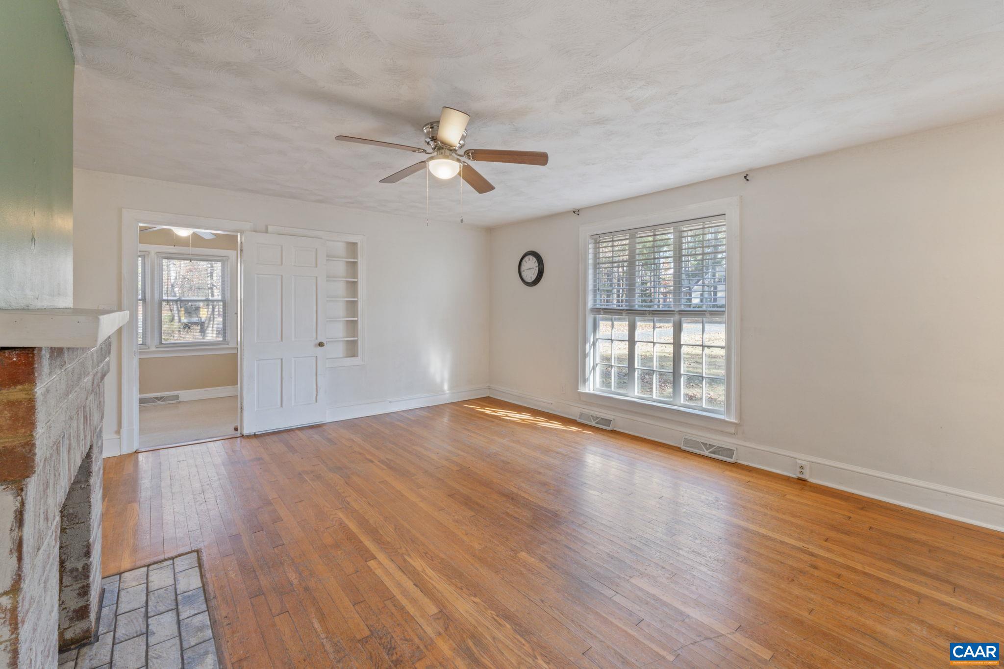 371 Fanny White Road Buckingham, VA 23921 - Photo 10 of 43 an empty room with wooden floor fan and windows