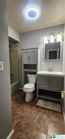 a bathroom with a toilet sink and mirror