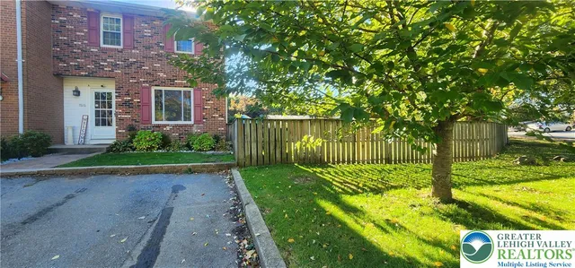 a view of a back yard with plants and large trees