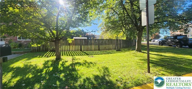 a view of backyard with swimming pool and green space