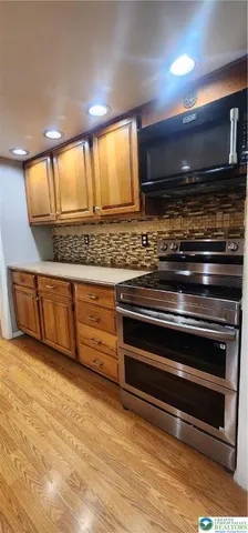 a stove top oven sitting inside of a kitchen