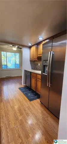a kitchen with granite countertop a oven a refrigerator and a wooden cabinets