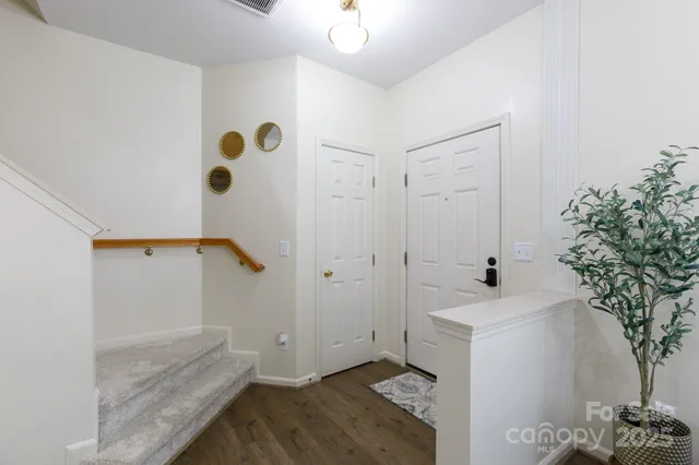 a dining room with wooden floor a chandelier a wooden table and chairs