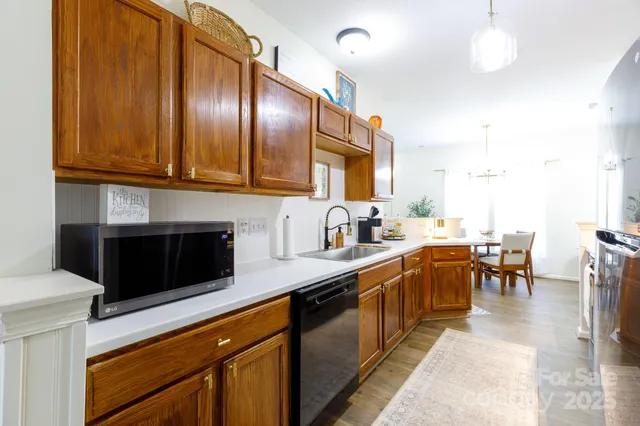 a kitchen with stainless steel appliances a refrigerator a stove a sink a dining table and chairs