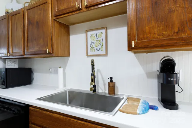 a kitchen with stainless steel appliances granite countertop a stove a sink and a microwave