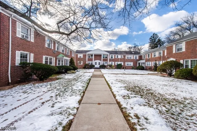 a view of residential houses with yard and trees