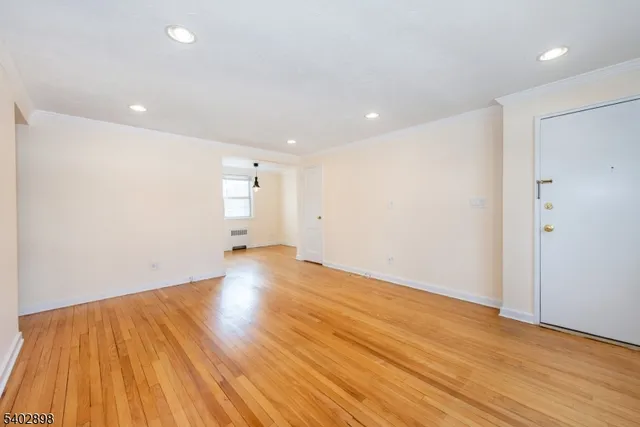 a view of empty room with wooden floor