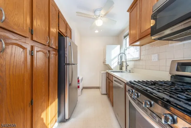 a kitchen with stainless steel appliances granite countertop a sink a stove and a refrigerator