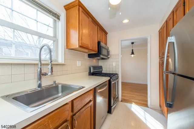 a kitchen with stainless steel appliances granite countertop a refrigerator a sink and a stove