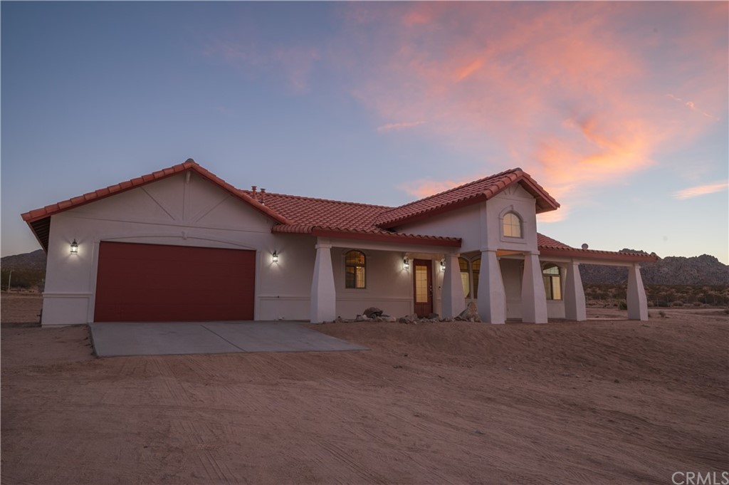 7022 Sunfair Road Joshua Tree, CA 92252 - Photo 1 of 1 a front view of a house with a yard and garage