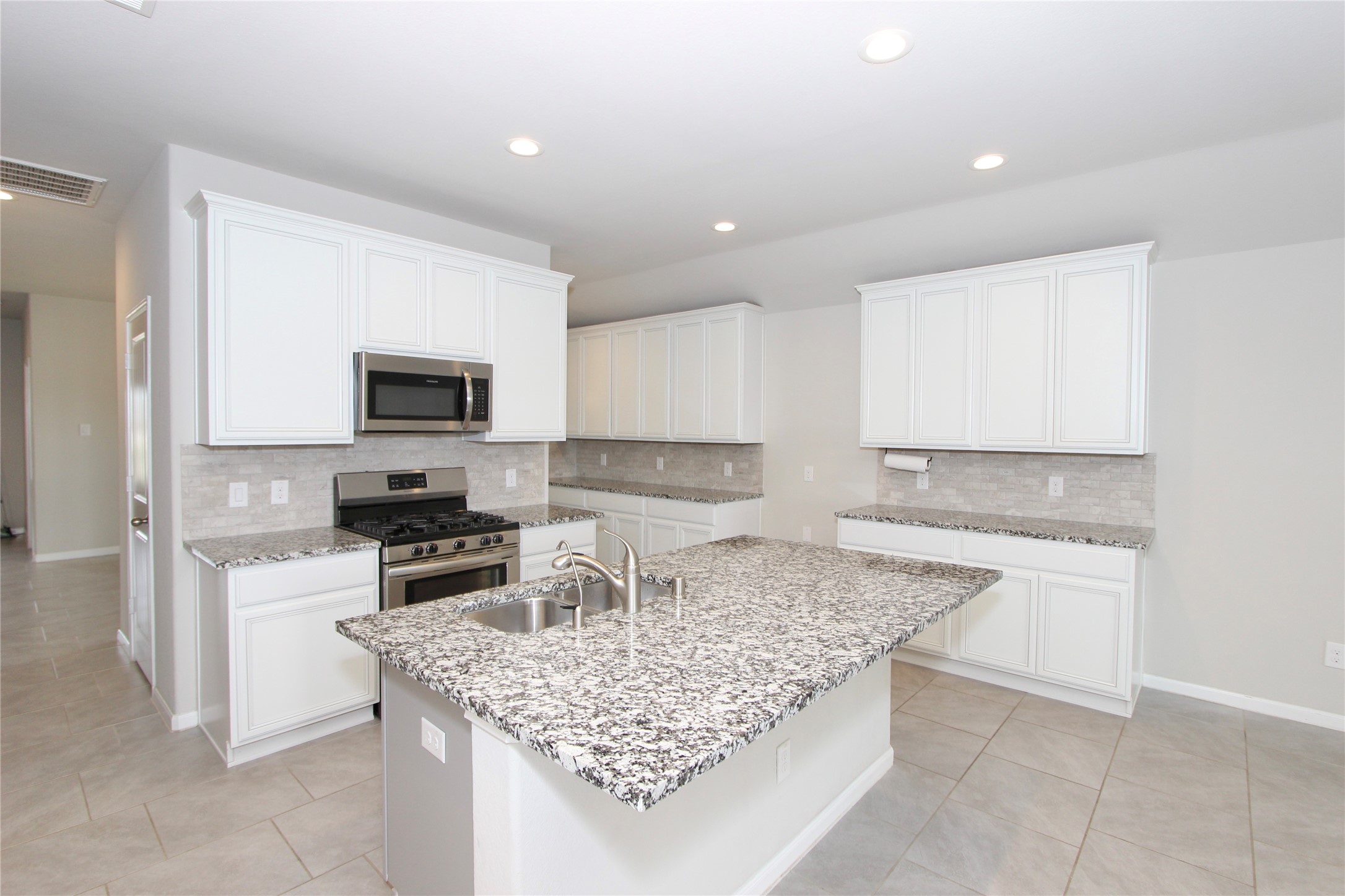 1303 Keaton Court Rosenberg, TX 77469 - Photo 3 of 22 a kitchen with granite countertop a sink stove and cabinets
