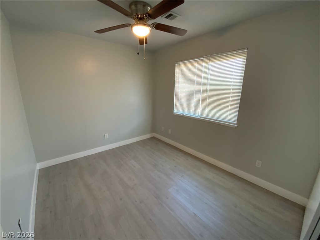 466 East Sunset Road, Unit C Henderson, NV 89011 - Photo 7 of 12 Empty room with visible vents, baseboards, light wood-style floors, and ceiling fan