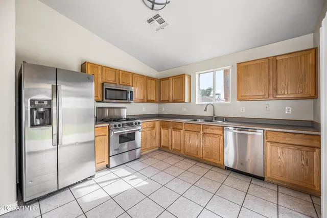 a kitchen with stainless steel appliances granite countertop a refrigerator and a sink