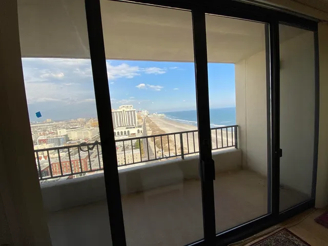 a view of empty room with wooden floor and windows
