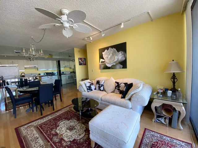 a living room with furniture and a view of kitchen