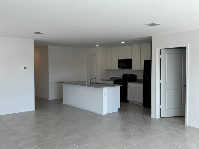a kitchen with a refrigerator and a stove top oven