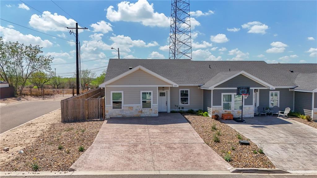 a front view of a house with a yard and potted plants