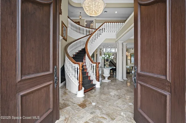 a living room with furniture a fireplace and a chandelier