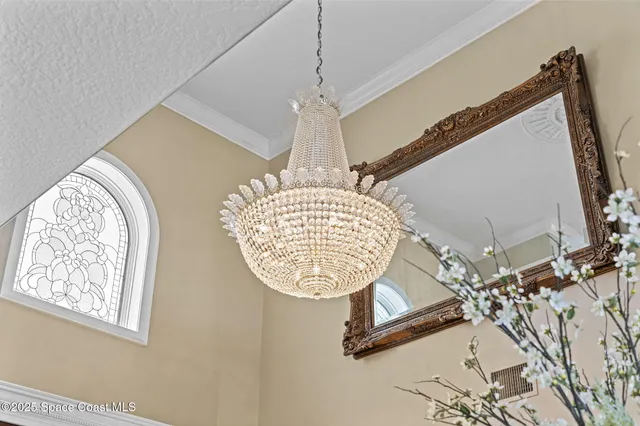 a living room with furniture chandelier and a large window