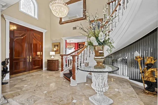 a living room with furniture a flat screen tv and a chandelier