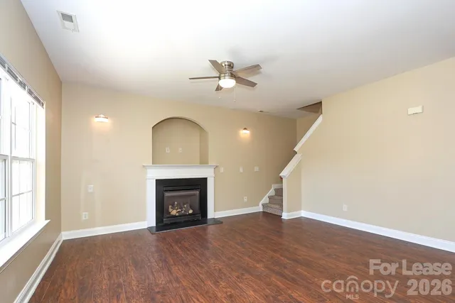 wooden floor fireplace and windows in an empty room