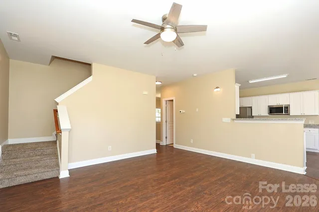 a view of a kitchen with wooden floor and a ceiling fan