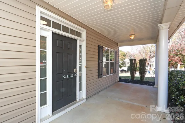 a view of a porch with wooden floor and floor to ceiling window