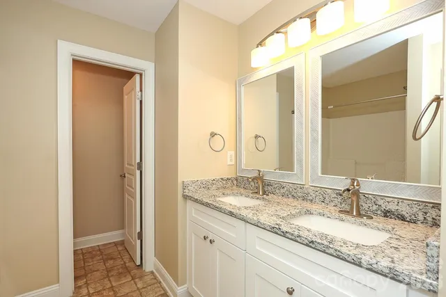 a bathroom with a granite countertop sink a mirror and a bathtub