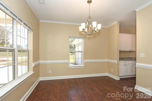 a view of a room with wooden floor cabinet and windows