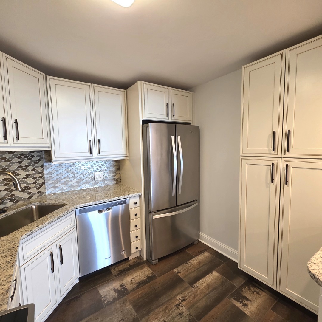 6033 North Sheridan Road, Unit 35F Chicago, IL 60660 - Photo 5 of 26 a kitchen with granite countertop a refrigerator and a sink