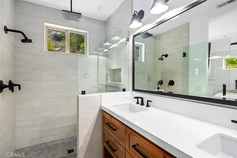 a bathroom with a sink a large mirror and a shower
