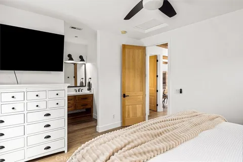 a bedroom with a bed and a flat tv screen in a dresser