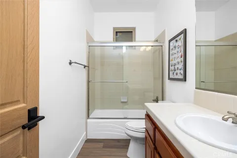 a bathroom with a granite countertop sink toilet and shower