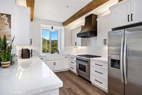a kitchen with stainless steel appliances a stove a sink and a refrigerator