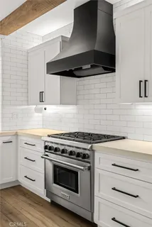 a kitchen with a stove and white cabinets
