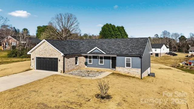 a view of house with yard and trees in the background