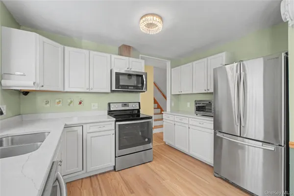 a kitchen with stainless steel appliances granite countertop a stove a sink and a refrigerator