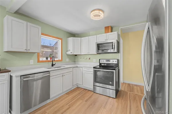 a kitchen with white cabinets and a window