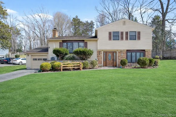 a front view of a house with a yard and trees