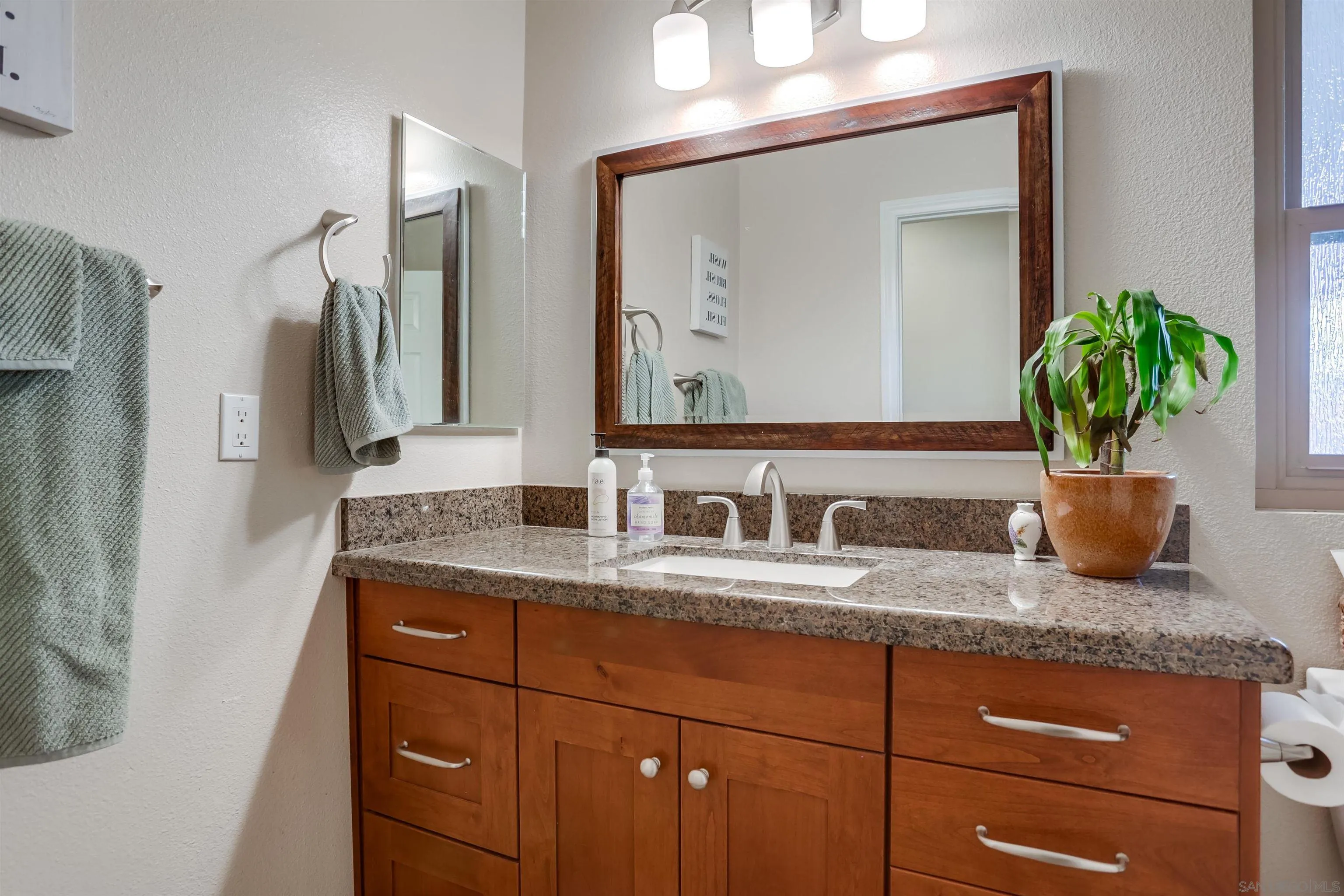 23409 Everett Place Ramona, CA 92065 - Photo 17 of 29 a bathroom with a granite countertop sink and a mirror