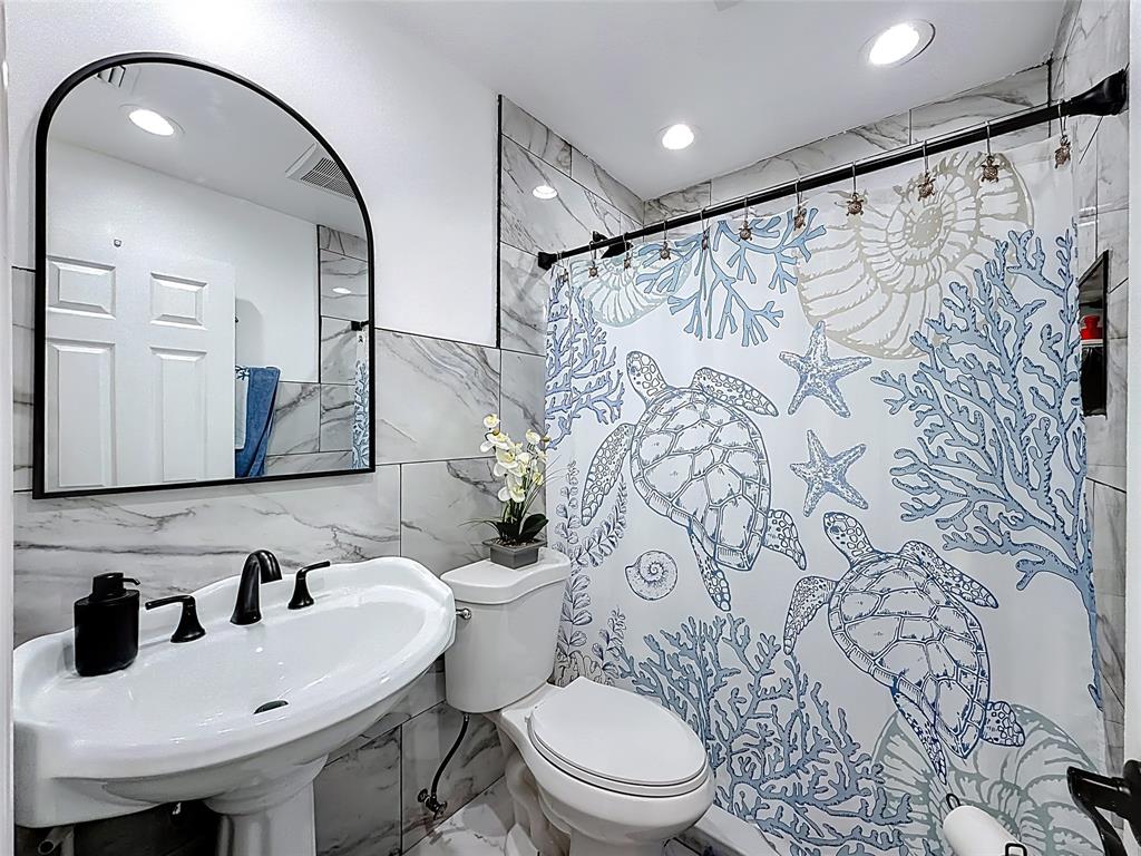 7141 Custer Street Hollywood, FL 33024 - Photo 15 of 84 a bathroom with a toilet sink and mirror