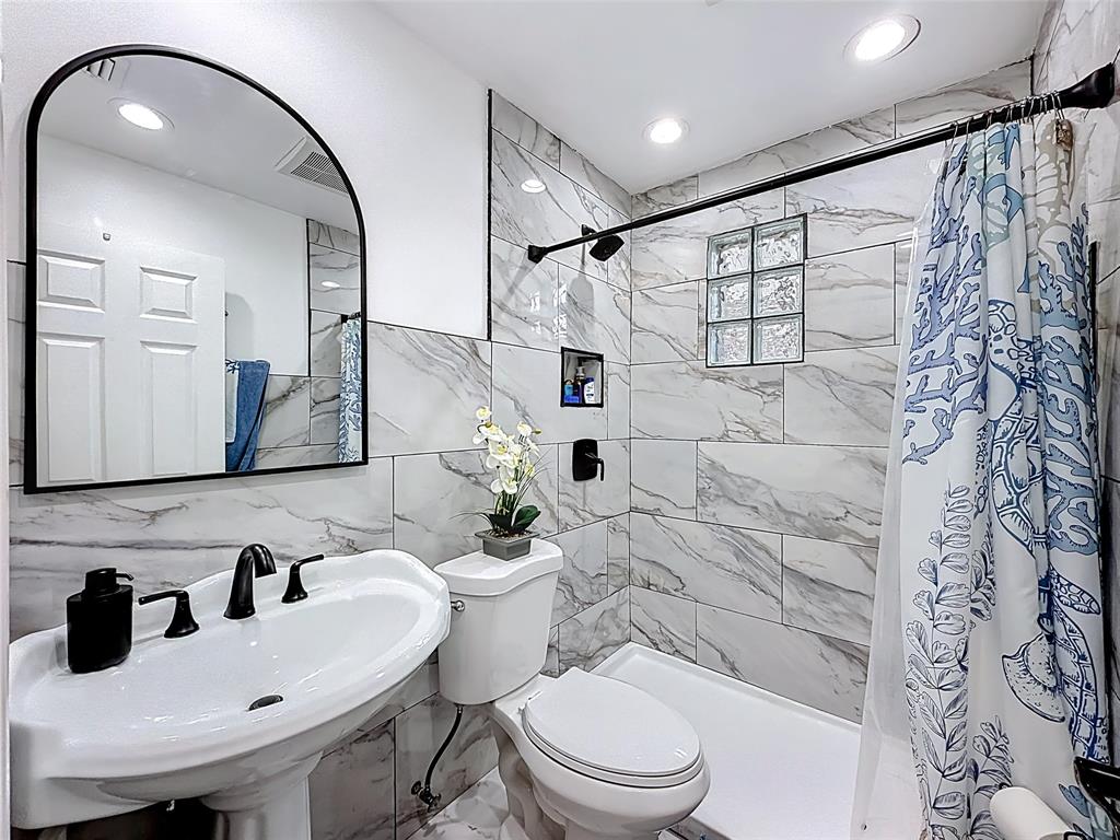 7141 Custer Street Hollywood, FL 33024 - Photo 16 of 84 a bathroom with a sink a toilet and a mirror