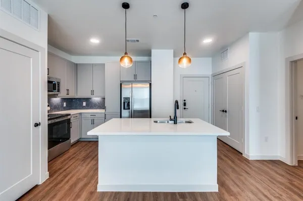 a kitchen with kitchen island a sink and a refrigerator