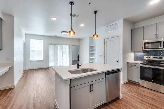 a kitchen with kitchen island white cabinets and stainless steel appliances